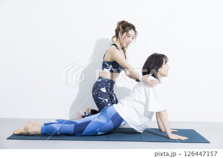 ヨガをする女性とインストラクター ヨガをする女性とインストラクター 126447157