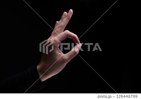 Female hand showing the ok gesture on a black background. Okey hand sign Female hand showing the ok gesture on a black background. Okey hand sign 126448799