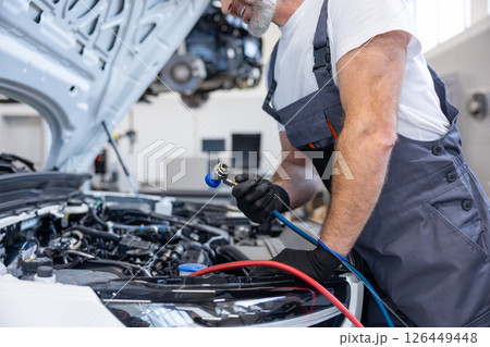 Mechanic with toolbox and laptop in workshop 126449448