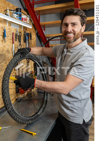 Mechanic in black gloves holding wheel 126451181