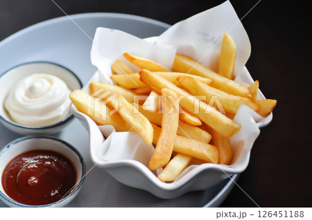 French fries or fried potato , fries with keychup and cheese dip 126451188