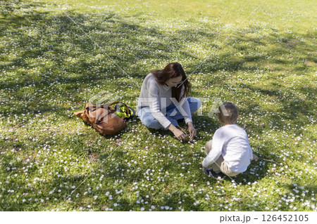 Mother and son picking daisies in a field of flowers 126452105