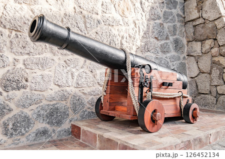 old cannon against background of stone wall of fortress old cannon against background of stone wall of fortress 126452134