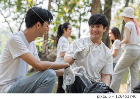 Two young men smiling while participating in a community cleanup event Two young men smiling while participating in a community cleanup event 126452740