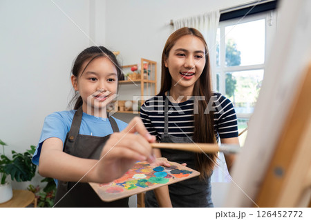 Family time creating art together: Mother and daughter enjoying painting Family time creating art together: Mother and daughter enjoying painting 126452772