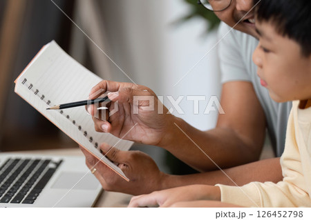 Homeschool learning experience with father and son using a notebook 126452798