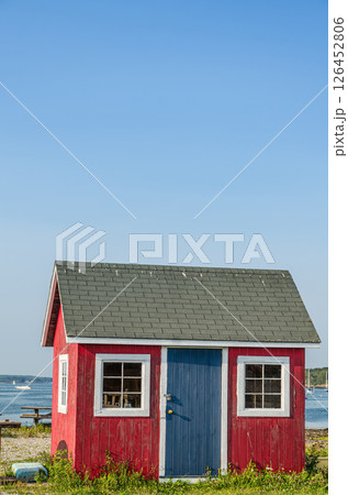 Red wooden fishing shack against the clear blue sky, Maine, New England, USA Red wooden fishing shack against the clear blue sky, Maine, New England, USA 126452806