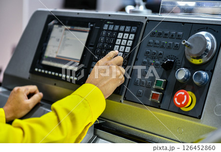 Close up Machine operator hand turns on control panel of industrial machine. technician push button on control pannel Close up Machine operator hand turns on control panel of industrial machine. technician push button on control pannel 126452860