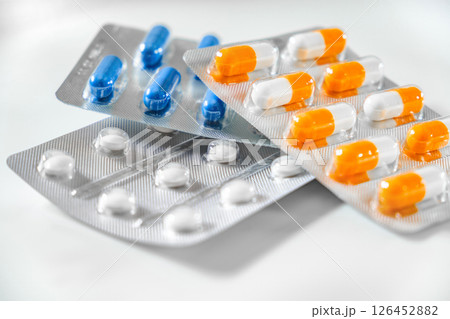 medical orange blue and white pills capsules in blisters, selective focus 126452882