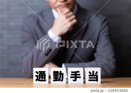 通勤手当のブロックとスーツを着て悩むミドル男性ビジネスマン 通勤手当のブロックとスーツを着て悩むミドル男性ビジネスマン 126453688