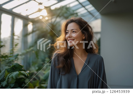 Smiling Woman in Sunlit Greenhouse Smiling Woman in Sunlit Greenhouse 126453939