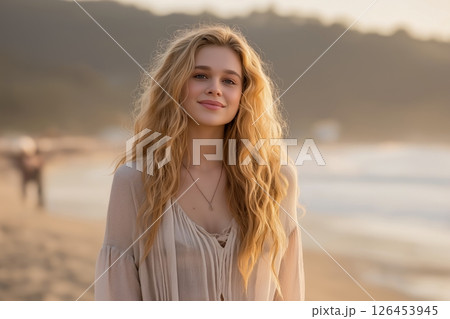 Smiling Young Woman with Blonde Hair on Sandy Beach at Sunset 126453945