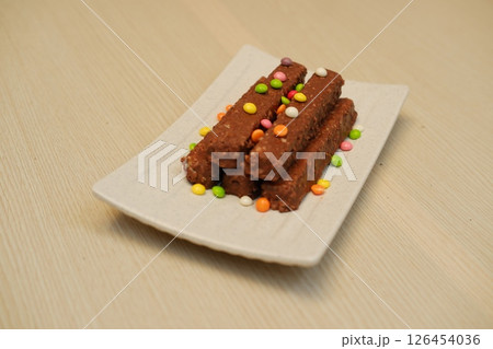 Chocolate Bars with Colorful Sprinkles on a White Plate Chocolate Bars with Colorful Sprinkles on a White Plate 126454036