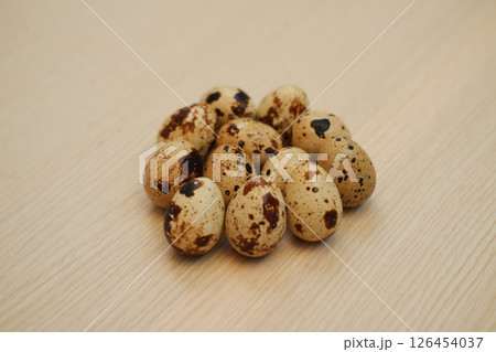 Pile of speckled quail eggs on a wooden surface Pile of speckled quail eggs on a wooden surface 126454037