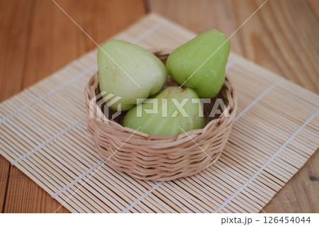 Rose Apple in a Woven Basket on a Wooden Mat 126454044