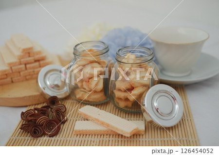 Cookies in a glass jar with tea cup Cookies in a glass jar with tea cup 126454052