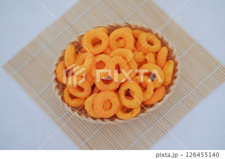 A basket of delicious orange cheese puffs, a popular snack. 126455140