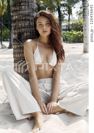 Beautiful young woman under palm tree Beautiful young woman under palm tree 126456645