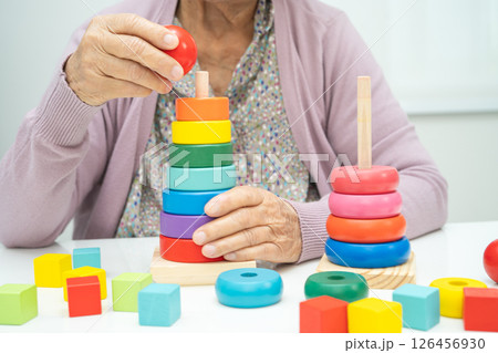 Asian elderly woman patient suffering from dementia learn practical motor skills rehabilitation. 126456930