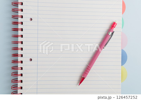 Open blank spiral bound lined notebook and pen 126457252