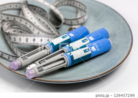 Ozempic Insulin injection pen for diabetics and weight loss on a plate with vegetables. Medical equipment for diabetes parients. 126457299