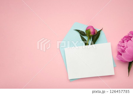 Pink peony with open envelope on pink background. 126457785