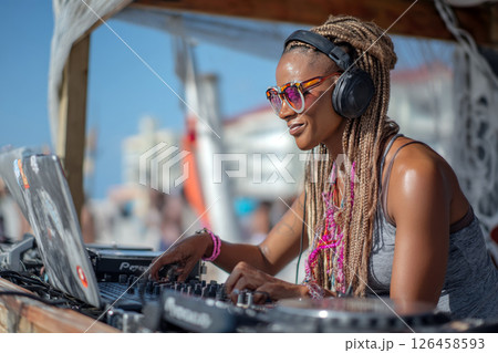 Female DJ Mixing Music Outdoors at Vibrant Summer Beach Party. 126458593