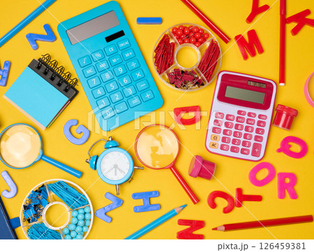 Colorful school supplies, learning items calculators, letters, tools, and stationery scattered on a vibrant yellow background. Colorful school supplies, learning items calculators, letters, tools, and stationery scattered on a vibrant yellow background. 126459381