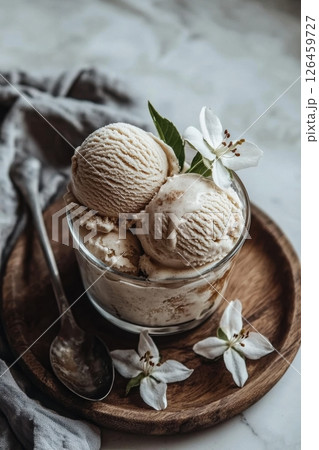 Vanilla ice cream with a decorative garnish in a glass bowl on a wooden tray 126459727