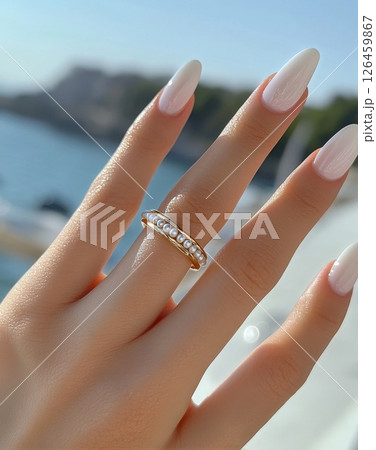 Elegant White Nails Adorned With Pearl Rings by the Beach at Sunset 126459867