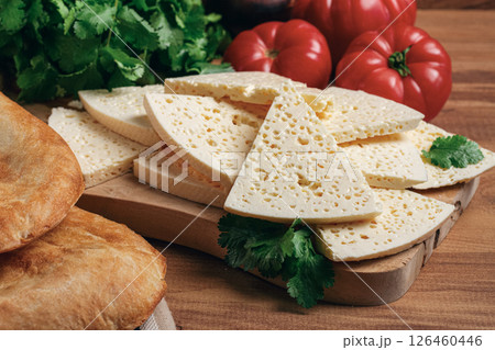 Georgian sliced cheese,on a wooden chopping board, with tomatoes with herbs and lavash, rustic style, Georgian cuisine, no people Georgian sliced cheese,on a wooden chopping board, with tomatoes with herbs and lavash, rustic style, Georgian cuisine, no people 126460446