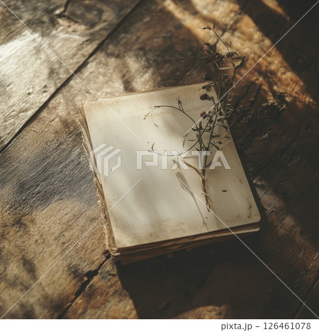 A beautiful invitation card mockup held over a rustic wooden table. Natural light and soft shadows create warm tones, giving an intimate and charming atmosphere perfect for events. 126461078