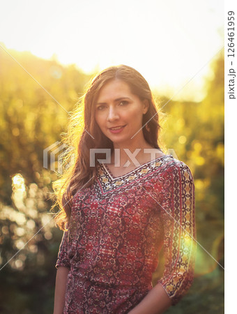 Portrait of young woman in casual summer dress, strong sunset backlight with nice bokeh 126461959