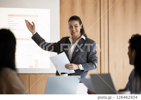 Young female trainer presenting visual data to diverse seminar participants 126462934