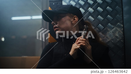 Action Movie Scene: Female Police Officer Hiding Behind the Wall, Holding a Gun Action Movie Scene: Female Police Officer Hiding Behind the Wall, Holding a Gun 126463642