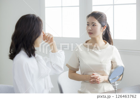 お肌のお手入れをアドバイスする女性 お肌のお手入れをアドバイスする女性 126463762
