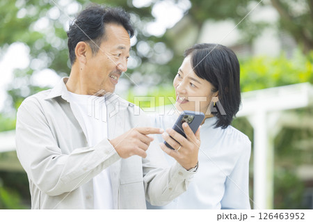 屋外でスマホを見るシニア夫婦 屋外でスマホを見るシニア夫婦 126463952