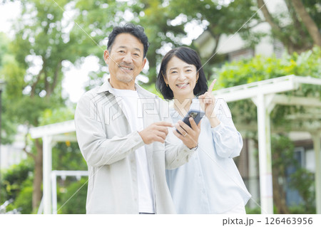 屋外でスマホを見るシニア夫婦 屋外でスマホを見るシニア夫婦 126463956