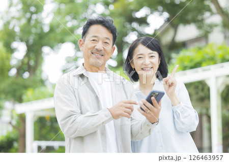 屋外でスマホを見るシニア夫婦 126463957