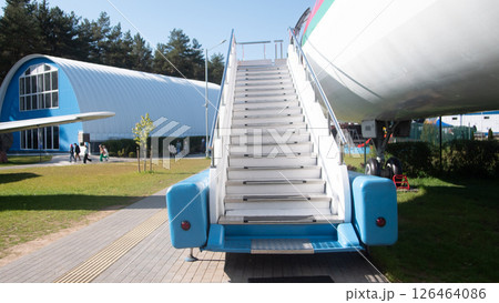 A vintage Soviet aircraft stands in a museum, featuring a set of stairs attached for visitors to explore. This exhibition highlights significant aviation history. 126464086