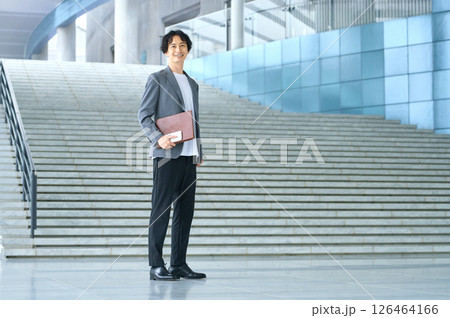 オフィスのエントランスに立つビジネスカジュアルの男性エンジニア オフィスのエントランスに立つビジネスカジュアルの男性エンジニア 126464166