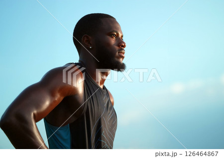 Determined Athlete Training Under a Clear Sky During Sunset at the Track 126464867