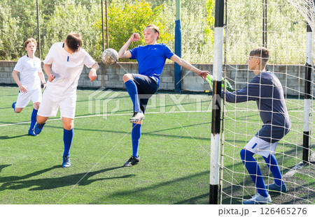 Youthful football players challenging for ball Youthful football players challenging for ball 126465276
