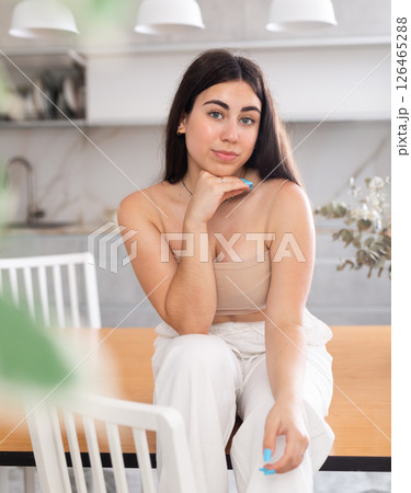 Young smiling woman posing in kitchen at home Young smiling woman posing in kitchen at home 126465288