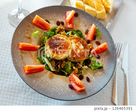 Salad with toasted goat cheese with fresh vegetables, greens, nuts Salad with toasted goat cheese with fresh vegetables, greens, nuts 126465391
