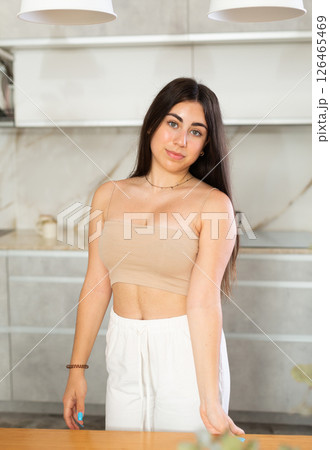 Young smiling woman posing in kitchen at home Young smiling woman posing in kitchen at home 126465469