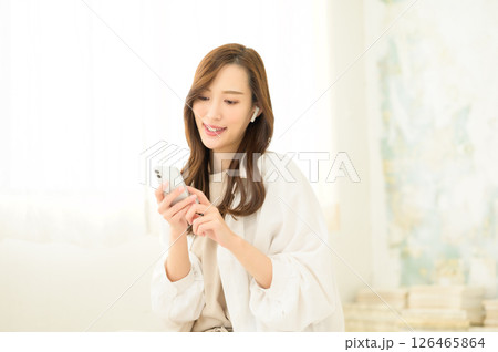 スマホで動画コンテンツを見る女性 スマホで動画コンテンツを見る女性 126465864