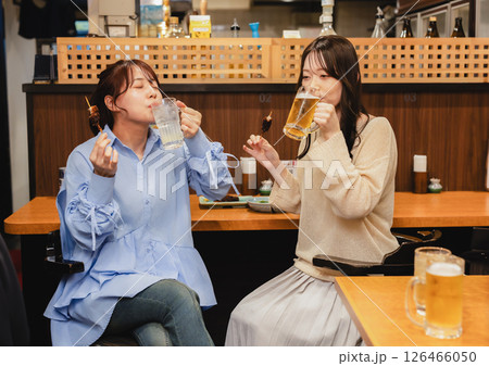 居酒屋のカウンターでお酒を飲む女性 126466050