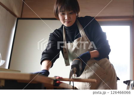 材木を電動のこぎりで切る女性 126466066