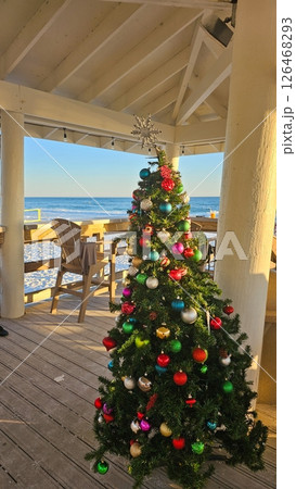 Beautiful Christmas Tree with Colorful Ornaments on a Beachfront Deck Scenery 126468293